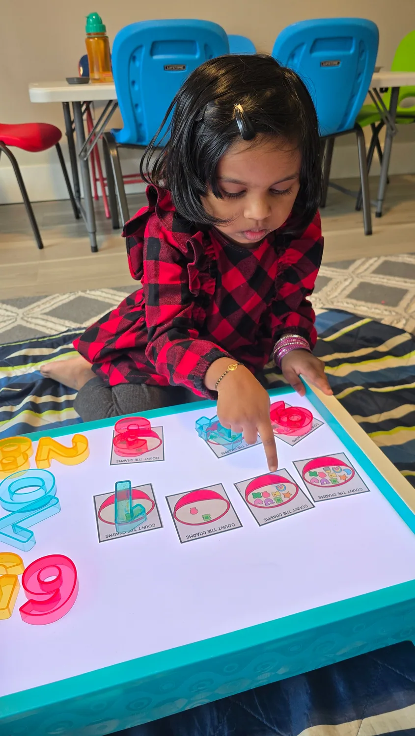 A child placing colorful counters on a mitten counting activity
